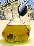 Olive pendant à un olivier au-dessus d'un flacon d'huile d'olive